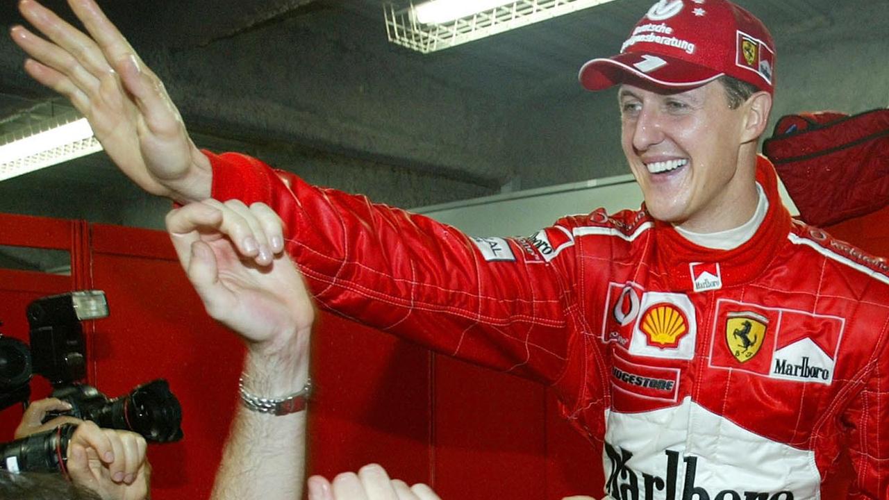 Michael Schumacher celebrates his World Champion victory with team members after the Japan F1 Grand Prix at Suzuka circuit in Suzuka, Japan, Oct. 12, 2003. (AP PicShizuo/Kambayashi)