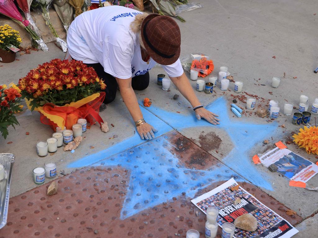 Chalk artist Elana Colombo draws the Star of David around the blood of Paul Kessler, a Jewish man who died during a protest in LA. Picture: AFP