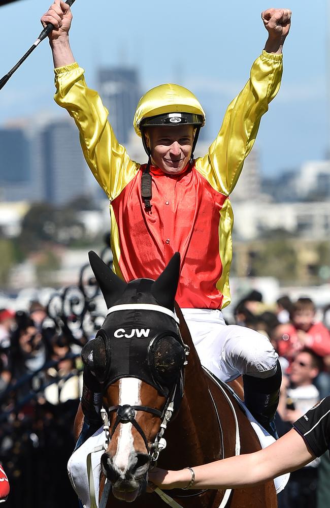 James McDonald raise his arms as the returns to scale aboard the Chris Waller-trained Delectation. Picture: AAP