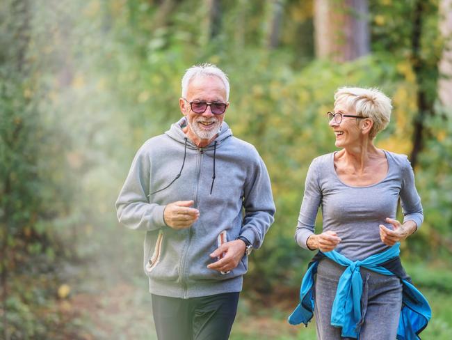 Smiling senior couple jogging in the park. Sports activities for elderly people. Active seniors generic