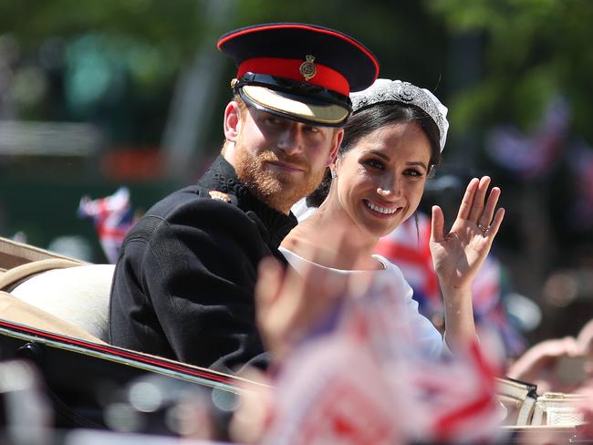 Just married, and ready for a beverage: The Duke and Duchess of Sussex wave from the Ascot Landau Carriage during their procession in Windsor. Picture: AFP/Daniel LEAL-OLIVAS