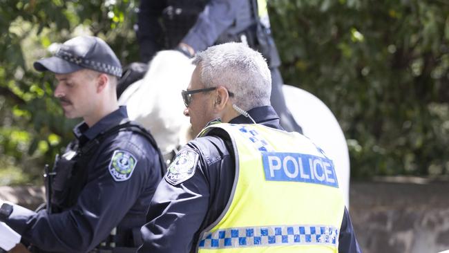 Police speak to three men outside the Botanic Gardens on North Terrace on Sunday. Picture: NewsWire / Brett Hartwig