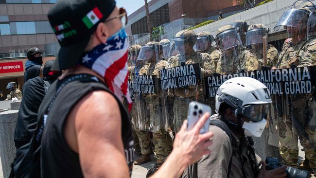 National Guard troops, police and protesters stand off outside a downtown federal jail in Los Angeles on Sunday local time. Spencer Platt/Getty Images/AFP
