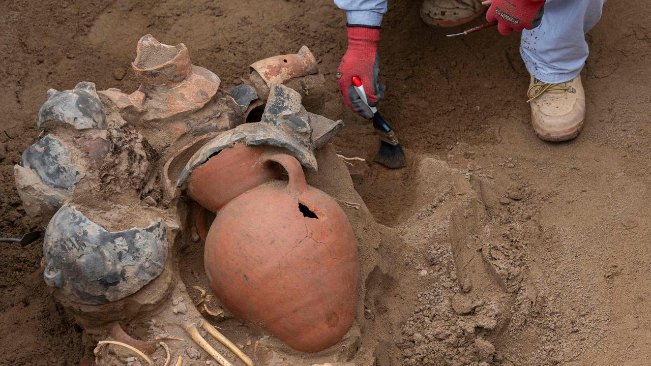 A work crew excavating a street in Lima to lay gas pipes found eight funerary bundles, including six children from a pre-Hispanic culture 800 to 1,000 years old, also containing pottery vessels and figurines. Picture: Cris Bouroncle / AFP