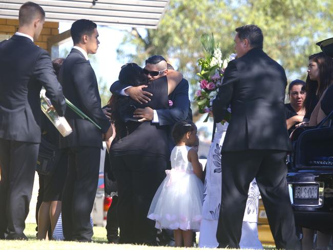 Topaz Hunia (glasses) is comforted at the funeral of his daughter. Picture: Bradley Hunter