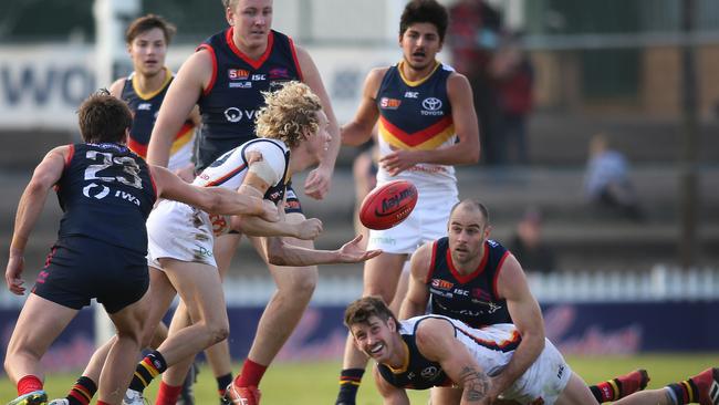 Adelaide's Douglas Hadden gets a handball out with some close attention by Norwood's Lewis Johnston. Picture: AAP IMAGE/DEAN MARTIN