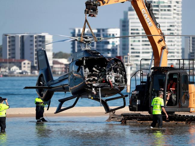 Queensland Police and ATSB Officers recover the wreckage of the second helicopter on Tuesday. Those onboard the relatively intact chopper all survived. Picture: Scott Powick