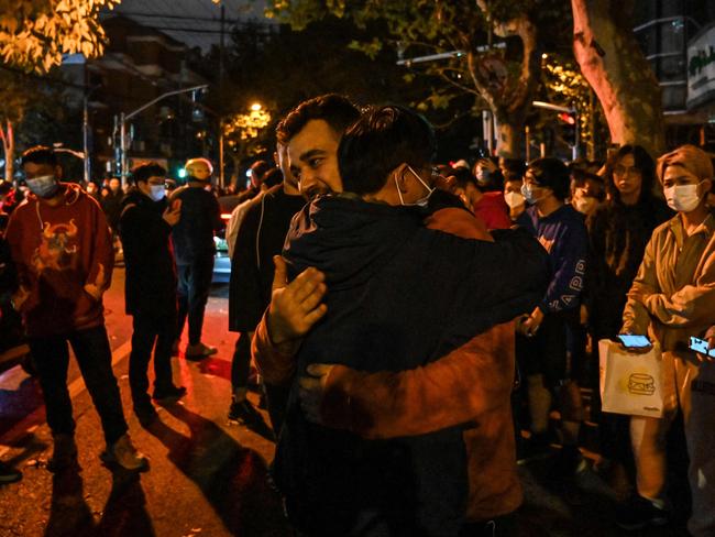 A man hugs another to show support in Shanghai where protests against China's zero-Covid policy took place the night before following a deadly fire in Urumqi. Picture: AFP.