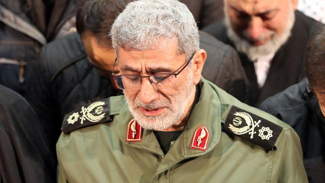 A handout picture provided by the office of Iran's supreme leader on January 6, 2020 shows the newly appointed commander of Iranian Revolutionary Guards Corps (IRGC), lieutenant general and commander of the Quds Force, Esmail Qaani (C), weeping over the coffin his predecessor Qasem Soleimani during their funeral ceremony in Tehran. The targeted killing of 62-year-old Soleimani ordered by US President Donald Trump saw Iran vow "severe revenge" before it also took a further step back from the already tattered 2015 nuclear accord with world powers. (Photo by HO / LEADER OFFICE / AFP) / / === RESTRICTED TO EDITORIAL USE - MANDATORY CREDIT "AFP PHOTO / HO / LEADER.IR" - NO MARKETING NO ADVERTISING CAMPAIGNS - DISTRIBUTED AS A SERVICE TO CLIENTS ===