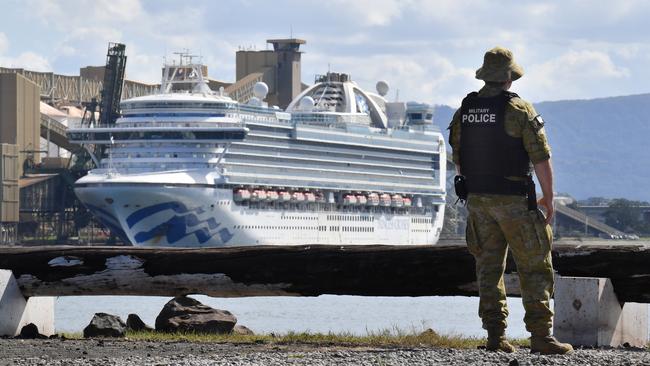 NSW Police and Australian Defence Force Military Police are seen in front of The Ruby Princess cruiseliner which remains docked at Port Kembla, Wollongong, Sunday, April 19, 2020. A criminal investigation has been launched into how cruise line operator Carnival Australia was allowed to disembark Ruby Princess passengers in Sydney, resulting in several deaths and COVID-19 outbreaks throughout the country. The Ruby Princess was due to depart Port Kembla today. (AAP Image/Dean Lewins) NO ARCHIVING