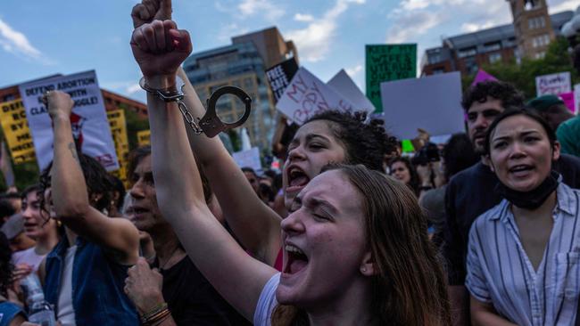 A handcuff hangs from the wrist of an abortion rights activist. Picture: Alex Kent / AFP