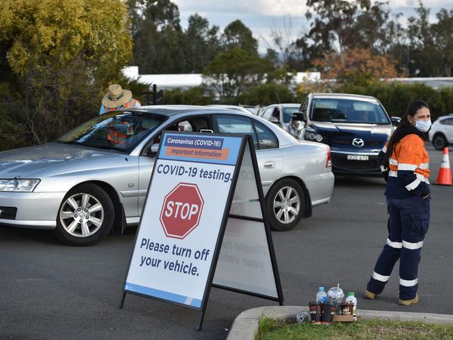 People queue up in their vehicles for a COVID-19 test at a testing station at the Crossroads Hotel, a popular drinking spot where at least 21 infections had been linked to a cluster there, in Sydney on July 13, 2020. - Sydney residents were warned on July 13 to put the brakes on partying as a new coronavirus cluster emerged at a city pub on the heels of a major outbreak in Melbourne. (Photo by PETER PARKS / AFP)