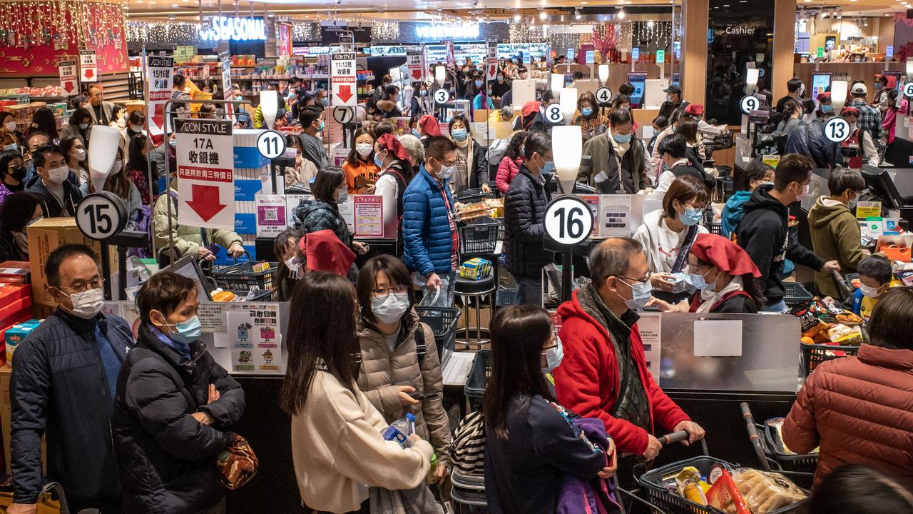 People wearing protective masks wait in line to make their purchase at a grocery store in a shopping mall on January 29 in Hong Kong. Picture: Anthony Kwan/Getty Images)