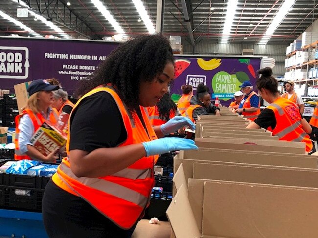 Lizzo helping pack food hampers at Foodbank for fire victims.