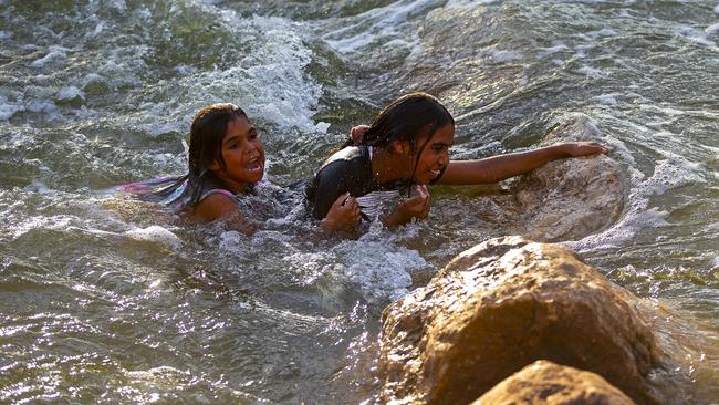 Girls swim against the current in the fishway at Brewarrina Weir. Picture: Jenny Evans/Getty Images