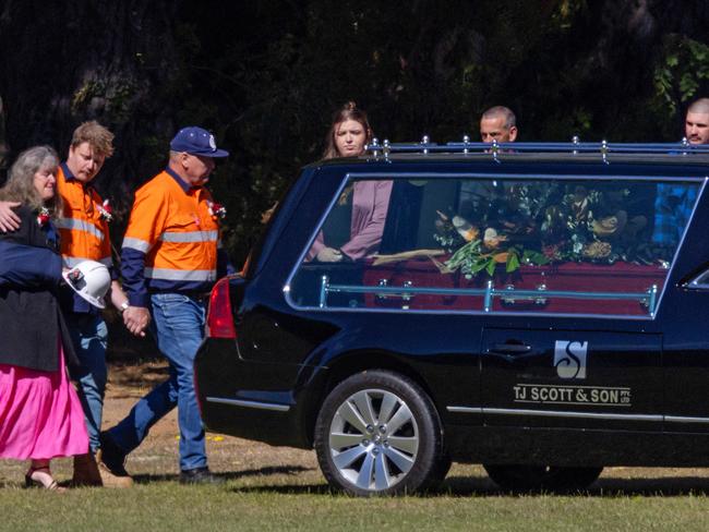 Miners and family members walk beside the hearse. Picture: Mark Stewart