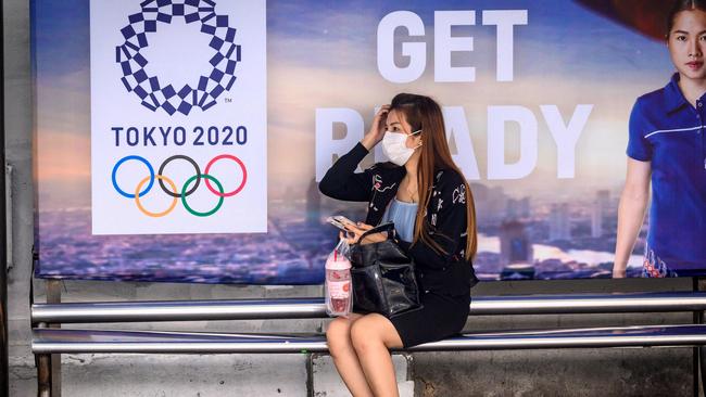 A woman wearing a facemask at a bus stop in Tokyo this week