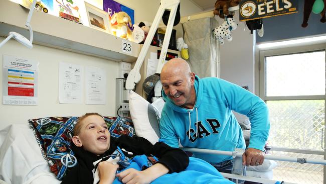 League great Brett Kenn with his stepson Riley who is being treated for a spinal injury at The Children’s Hospital at Westmead. Picture: Tim Hunter