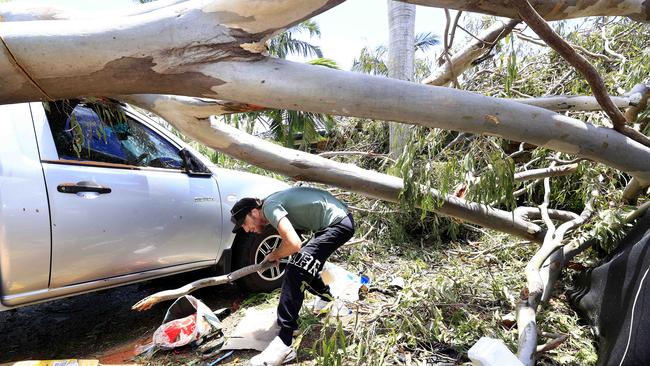 Damian Wheeler helps friends with the massive clean up after the Christmas night storm on the Gold Coast. Picture: Adam Head