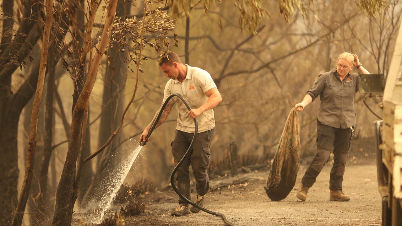 Chad Staples puts out a spot fire at during last summer’s bushfires. Picture: John Grainger