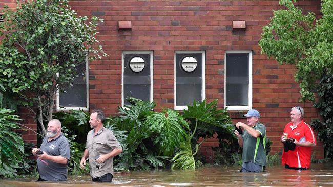 Staff of the Camden Sports Club wade through the floodwaters to enter into the building on March 8. Picture: Muhammad Farooq/AFP