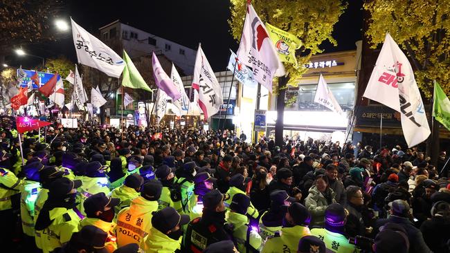 Protesters demonstrate against the country's president as police stand guard in Seoul, South Korea.