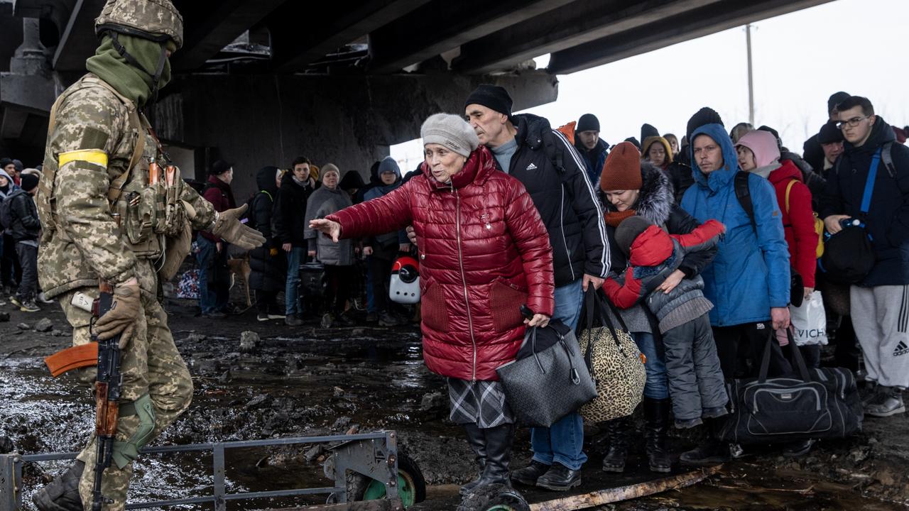 Residents of Irpin flee heavy fighting via a destroyed bridge as Russian forces entered the city. Picture: Getty Images