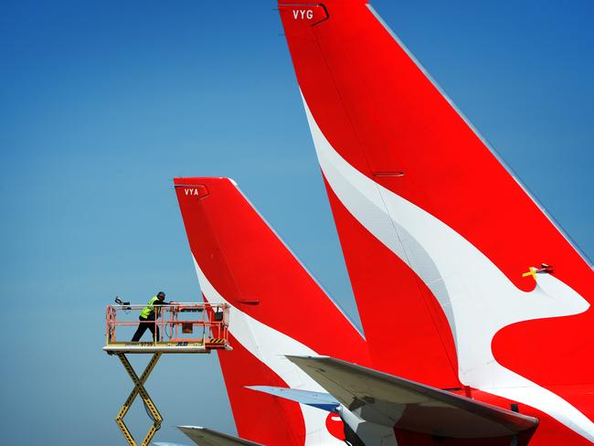 MELBOURNE, AUSTRALIA - NewsWire Photos NOVEMBER 22, 2021: A maintenance worker inspects the tails of QANTAS planes parked at Melbourne Airport. Picture: NCA NewsWire / Andrew Henshaw