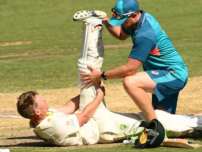 MELBOURNE, AUSTRALIA - DECEMBER 27: David Warner of Australia is treated for cramps during day two of the Second Test match in the series between Australia and South Africa at Melbourne Cricket Ground on December 27, 2022 in Melbourne, Australia. (Photo by Quinn Rooney/Getty Images)