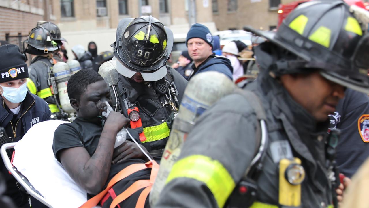 An injured resident is taken for medical care by firefighters attending the Bronx blaze. Picture: G.N.Miller/NYPost
