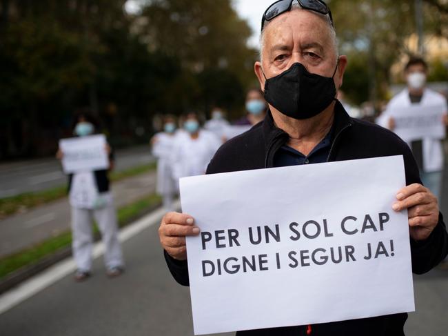 A patient stages a joint a protest with healthcare workers to demand better conditions in health centres in Barcelona. Picture: AFP