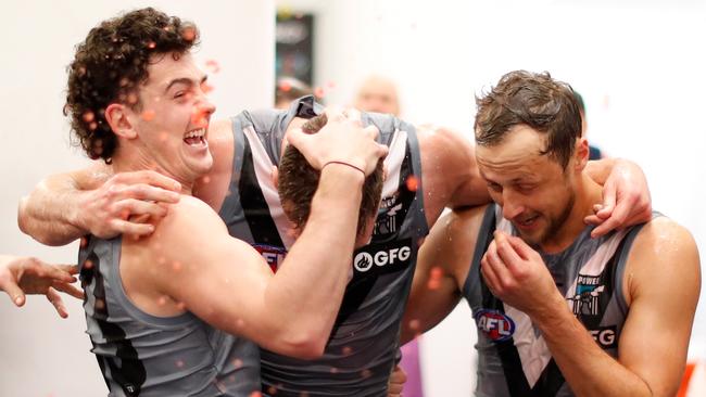 Darcy Byrne-Jones, Peter Ladhams and Cam Sutcliffe of the Power celebrate their win over the Bombers in Melbourne. Picture: Michael Willson