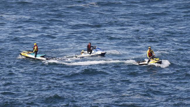 Surf lifesavers searching an area where two men were washed from rocks while rock fishing late yesterday. Picture: Richard Dobson