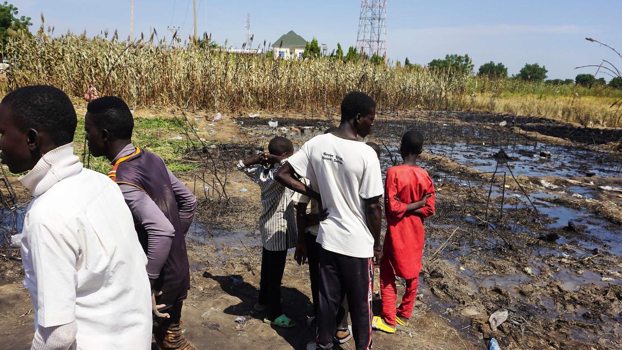 Residents look at the site of an explosion of a fuel tanker that resulted in the death of almost 150 people in Majiya on October 16, 2024. (Photo by Aminu ABUBAKAR / AFP)