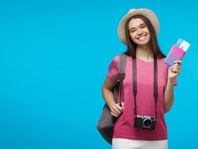 A young female traveller with her camera and boarding passes and about to leave on an overseas holiday. Picture: iStock.