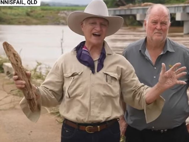 Bob Katter brandishes a piece of driftwood.