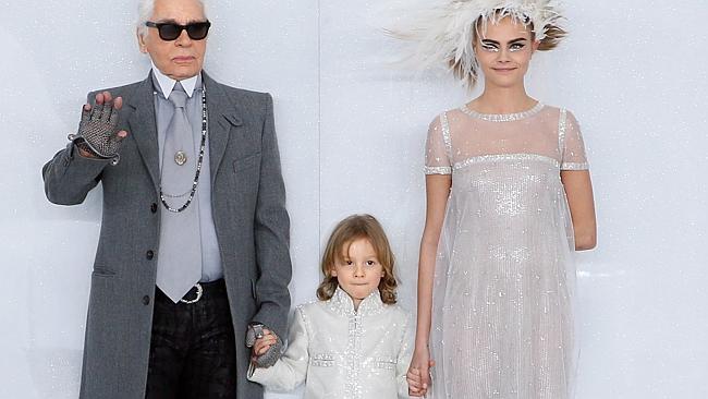 German fashion designer Karl Lagerfeld acknowledges the public along with his godson Hudson Kroening and British model Cara D...