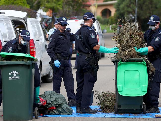 Police search bins looking for evidence in Tallowwood Ave. Picture: Toby Zerna