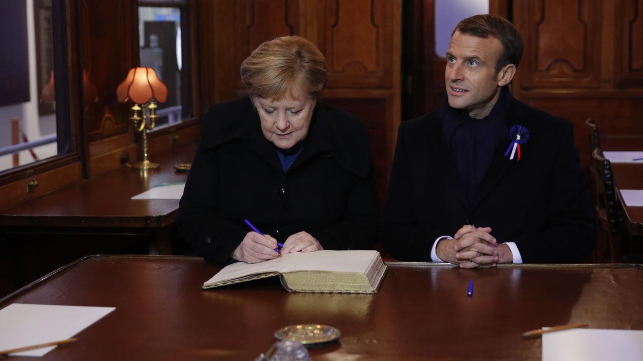 French President Emmanuel Macron and German Chancellor Angela Merkel sign the Golden Book. Pic: AFP