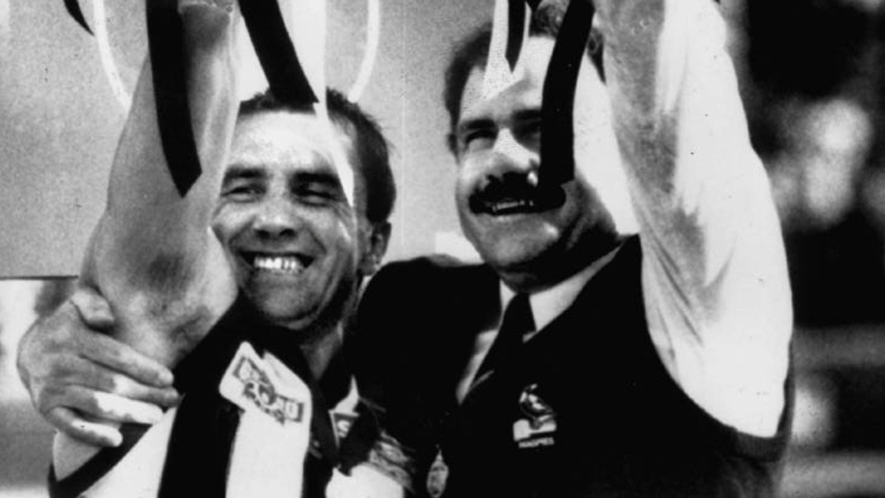 Collingwood aptain Tony Shaw and coach Leigh Matthews hold the premiership cup.