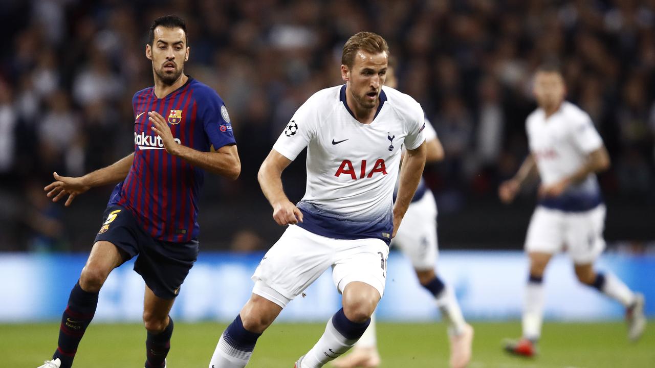 Harry Kane of Tottenham Hotspur runs with the ball under pressure form Sergio Busquets of Barcelona