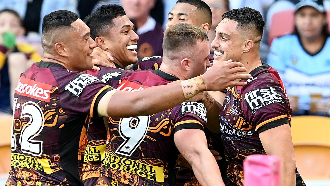 The Broncos celebrate a try with Kotoni Staggs (right).