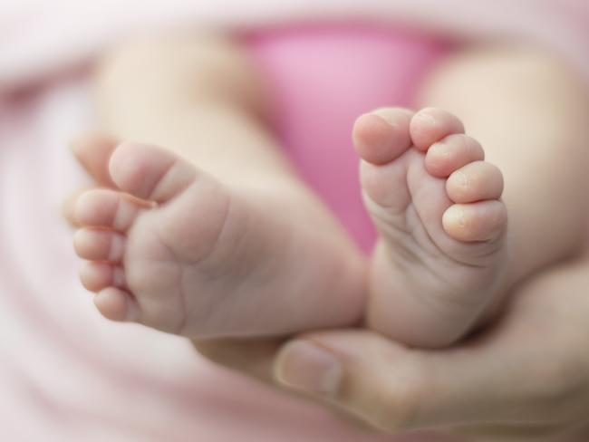 Newborn baby feet in the mother hands. Baby feet is covered with pink blanket. Strong feelings and emotions.  Picture: istock