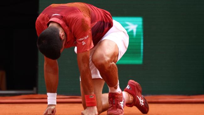 TOPSHOT - Serbia's Novak Djokovic reacts after falling on the court during his men's singles round of sixteen match against Argentina's Francisco Cerundolo on Court Philippe-Chatrier on day nine of the French Open tennis tournament at the Roland Garros Complex in Paris on June 3, 2024. (Photo by Emmanuel Dunand / AFP)