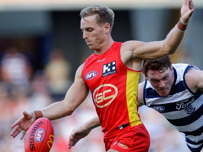 GOLD COAST, AUSTRALIA - APRIL 02: Darcy Macpherson of the Suns is tackled by Gary Rohan of the Cats during the 2023 AFL Round 03 match between the Gold Coast Suns and the Geelong Cats at Heritage Bank Stadium on April 2, 2023 in the Gold Coast, Australia. (Photo by Russell Freeman/AFL Photos via Getty Images)