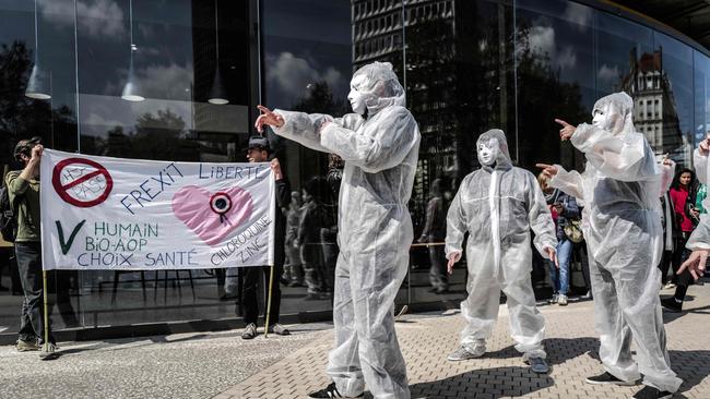 French nationalist party Les Patriotes supporters wearing protective coverall and masks, parade in Lyon, southeastern France, on April 17, during a rally of their party to protest against sanitary measures put in place to curb the spread of Covid.