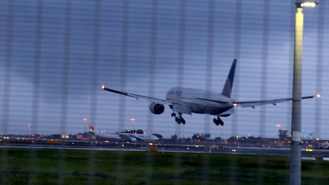 Airport A plane lands at Sydney airport as another rain band hits