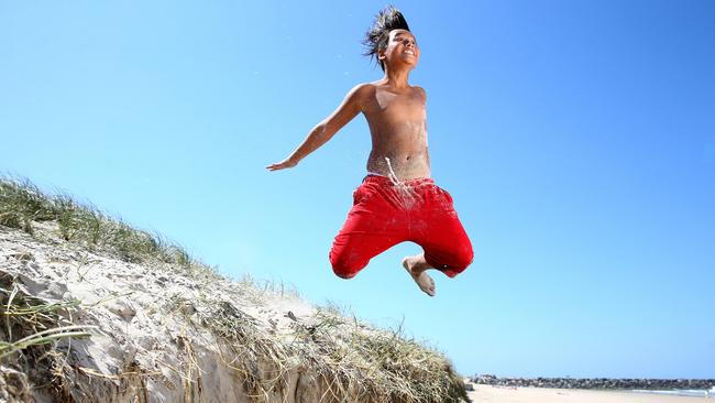 Timothy Davies 12 from Labrador enjoys playing on the erosion caused by the huge swells at the Spit on the Gold Coast. Pics Adam Head