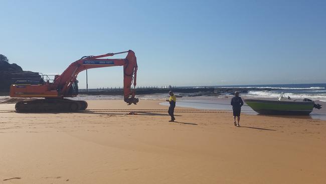 Northern Beaches Council contractors helped salvage a boat that was wallowing in the surf break at North Narrabeen Beach after it sprang a leak. Picture: Lewis Slarke