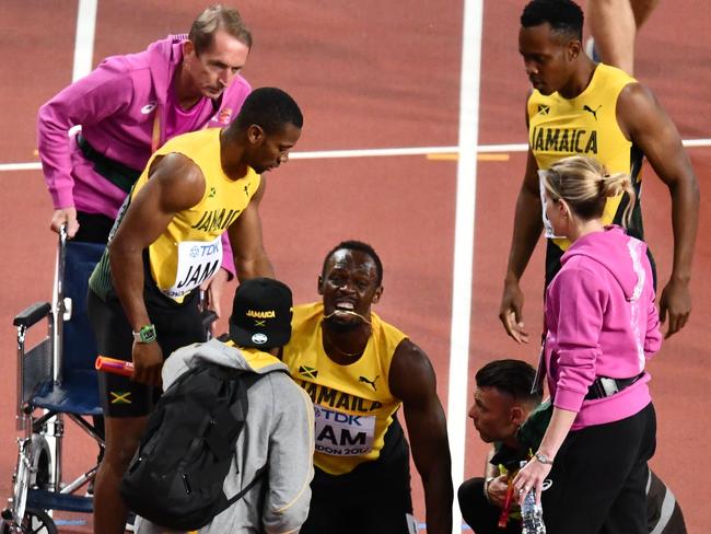 Medical staff and teammates surrounded Bolt on the track. Picture: AFP